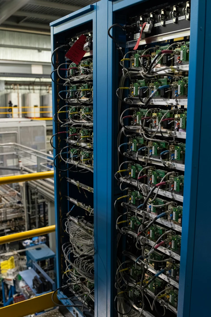 AI-generated photorealistic editorial illustration of a modern data centre beside British countryside, with an empty public consultation table in the foreground; no logos or text.
