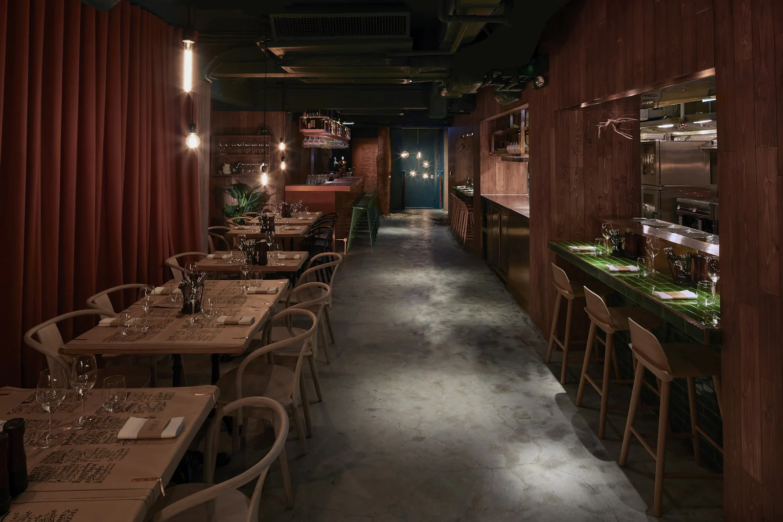 Contemporary restaurant interior with warm wooden tables and bar