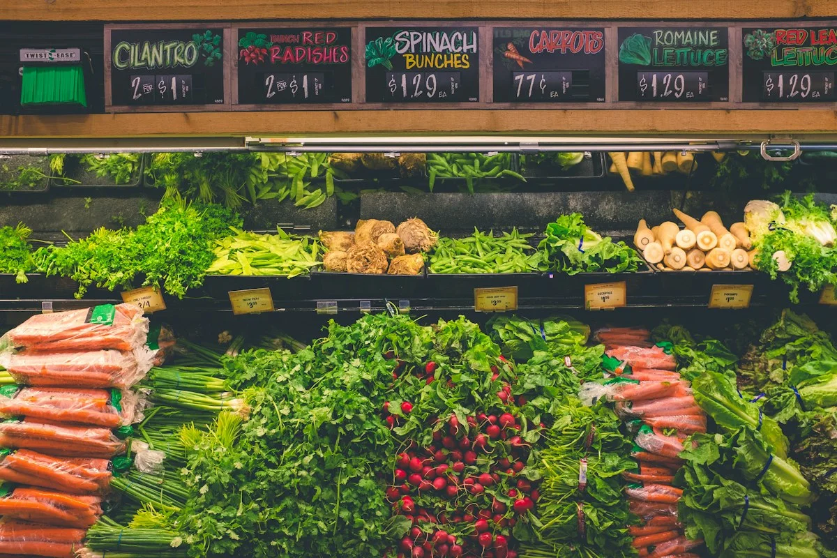 Illustrative photograph of vegetables and produce price signs in a market
